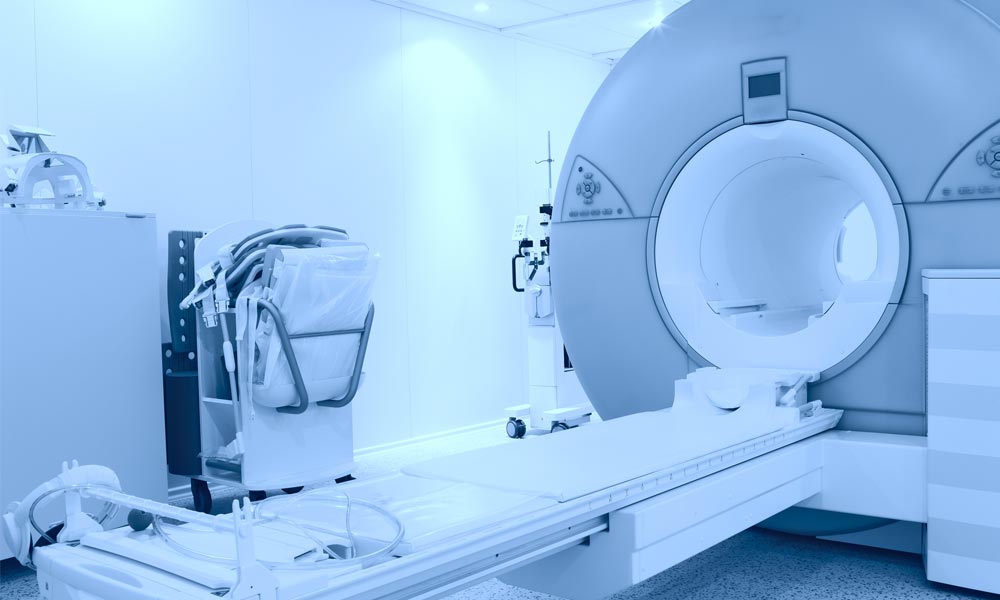 empty mri machine not in use in a white room with no patient present