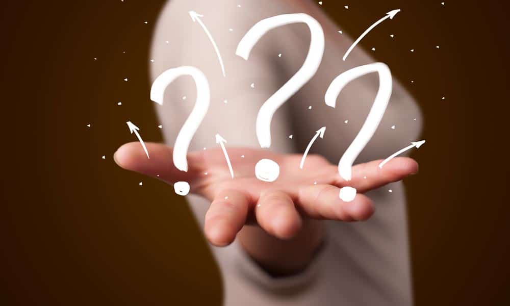 woman holding out her right hand with question marks on top