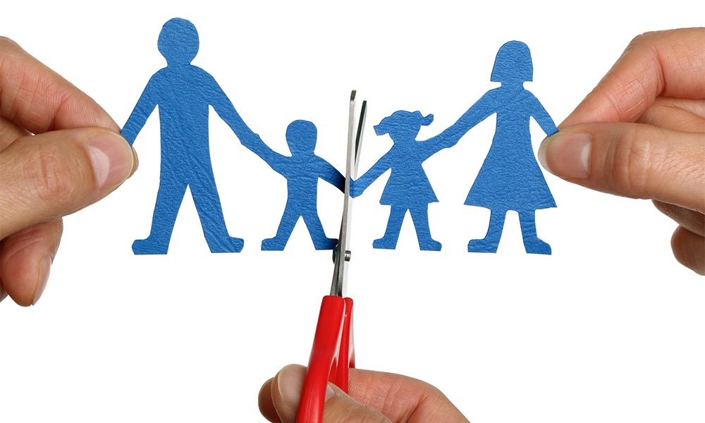 scissors separating a family made out of paper due to divorce