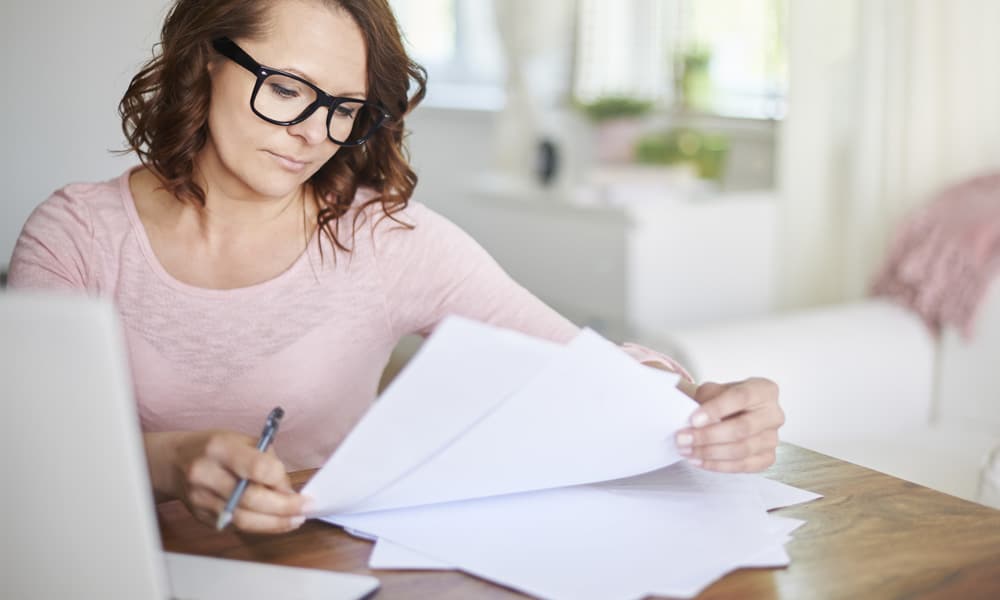 woman with glasses reviewing bills