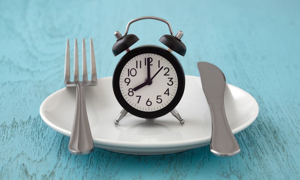 alarm clock on a plate with utensils